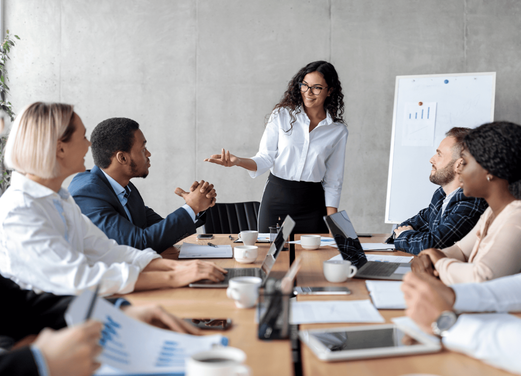 Gerente sorrindo conduzindo reunião com equipe